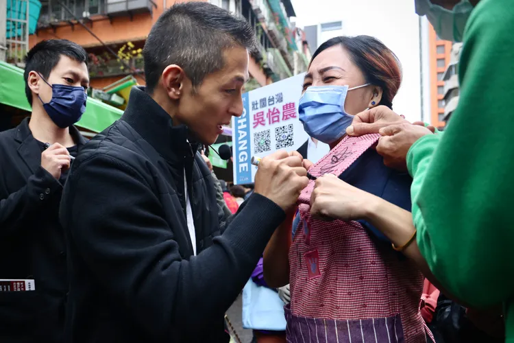 吳怡農今天到松山機場附近的濱江市場掃街，有熱情民眾索取簽名。林林攝