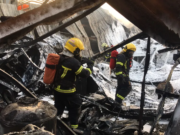 消防人員清理火場。讀者提供