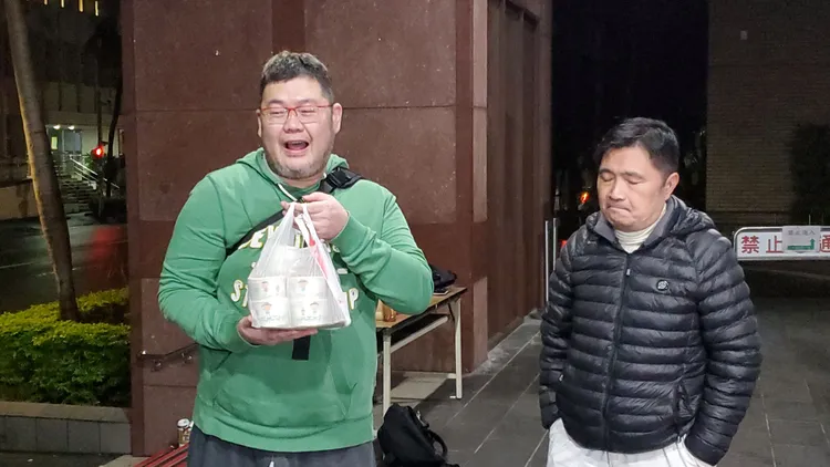 四叉貓在寒冷的夜晚拎著海鮮粥，到地檢署外湊熱鬧。呂志明攝