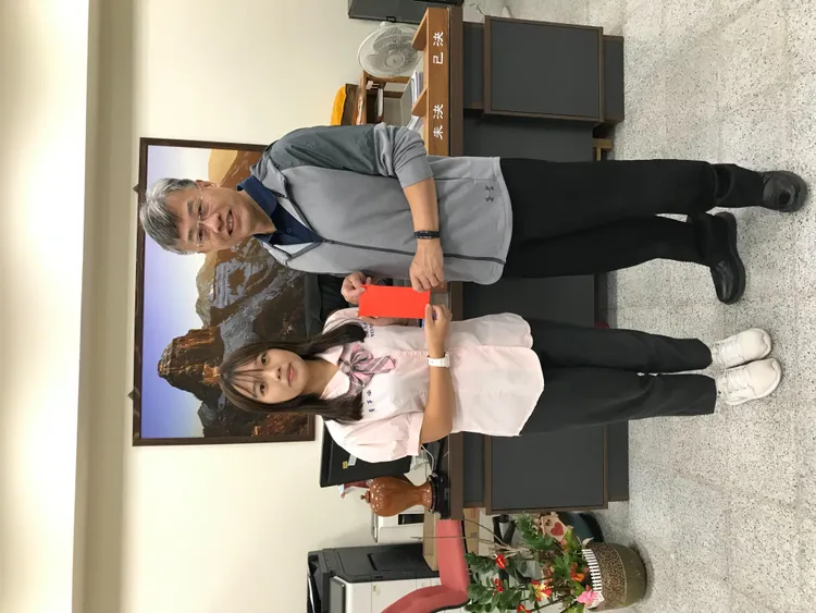 三義高中學生黃芊瑜獲錄取中央大學，校長李萬源贈送紅包恭喜。三義高中提供