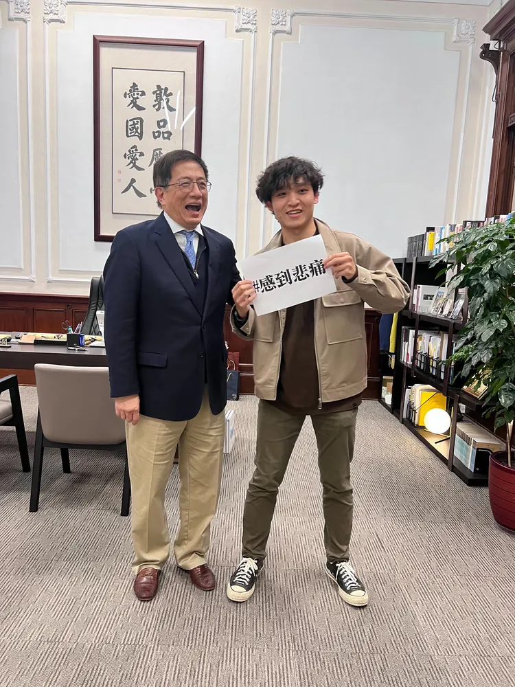 學生拿標語大玩「感到悲痛」梗，讓管中閔大笑。翻攝自管中閔臉書