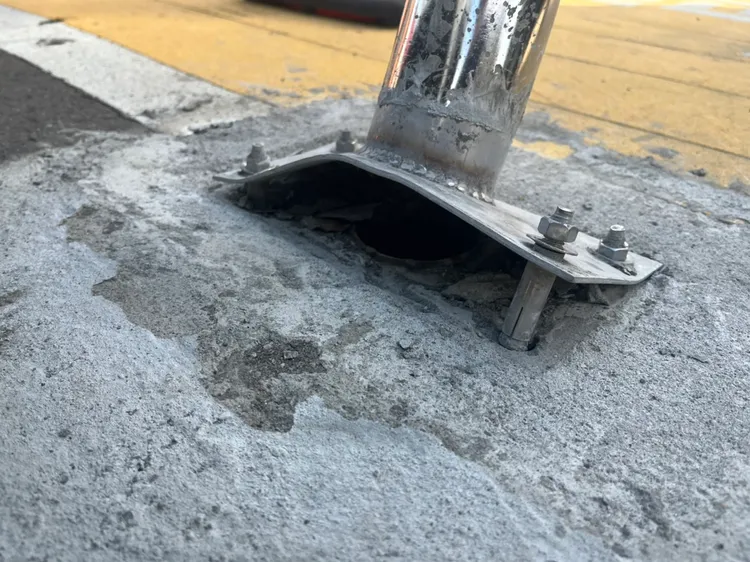 車擋底部並非插進洞內，且被撞後鐵製底座掀起、螺絲外露，容易造成民眾踢到受傷。周庭慶攝