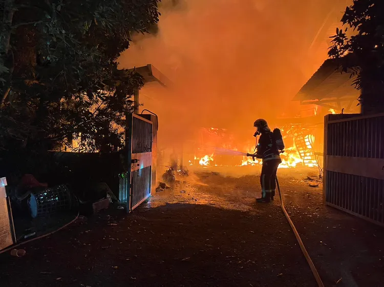 消防人員拉水線搶救。讀者提供