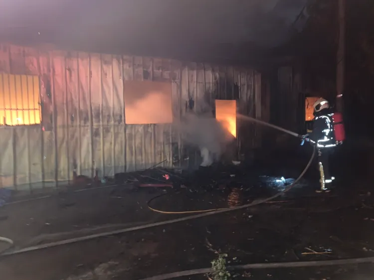 消防隊員朝起火的鐵皮搭蓋宮廟噴水灌救。讀者提供