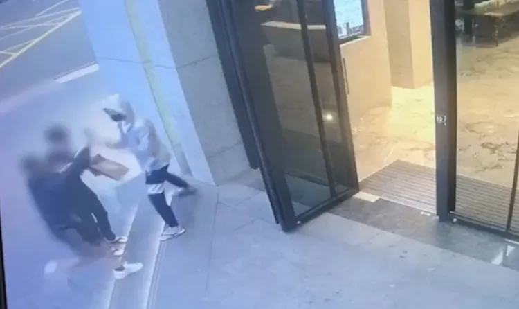 穿帽T的被害人唐姓男子從大樓走出取餐時，遭歹徒噴辣椒水強擄上車。讀者提供