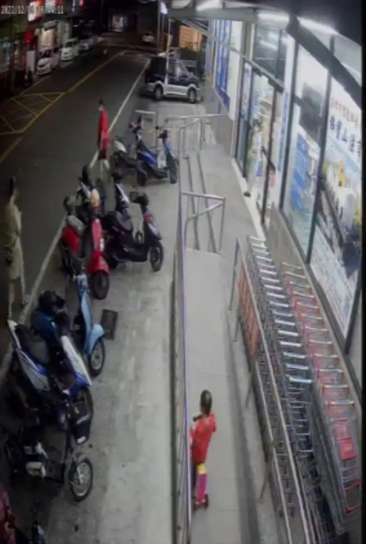 紅衣小男孩騎三輪車在殘障坡道，媽媽在後跟著，卻是低頭在滑手機。翻攝臉書社團我是岡山人（北高雄）