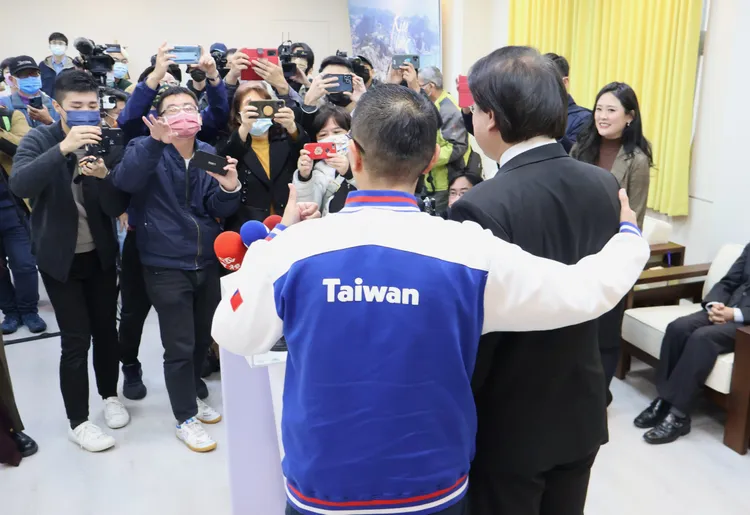 雙方合照時，謝國樑用手在林右昌的肩膀上表示親密。戴之聖攝