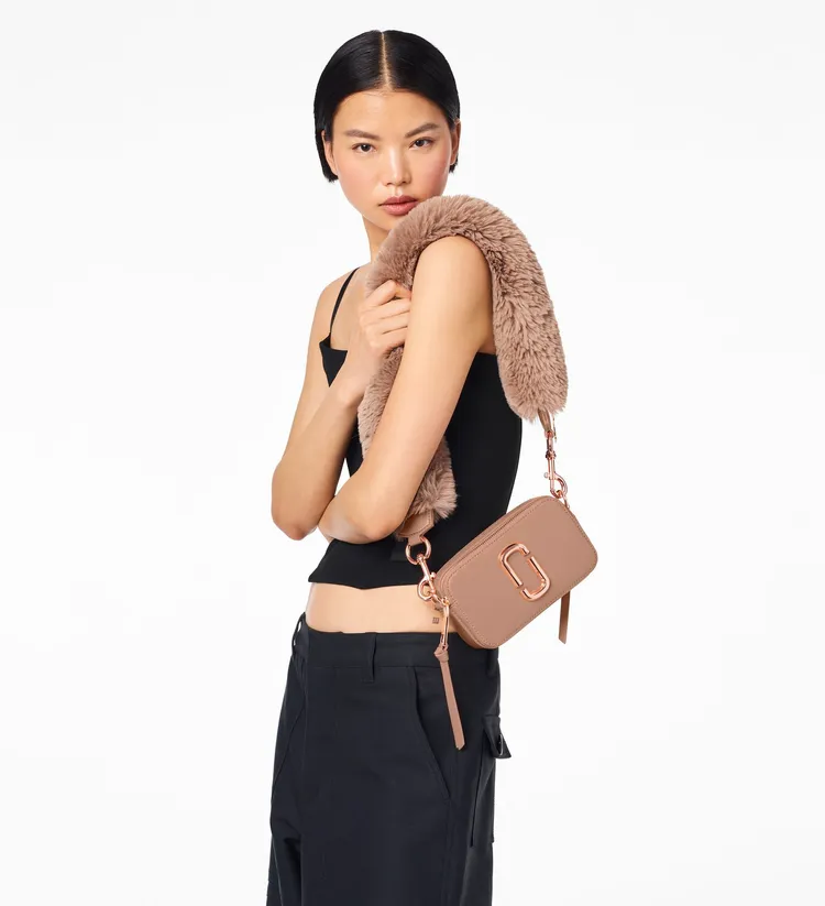 蜜桃粉Snapshot相機包搭配仿真兔毛背帶，1萬9900元。品牌提供