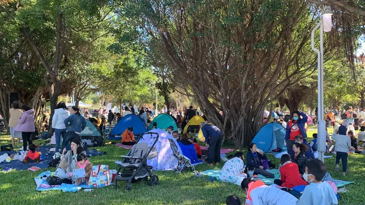 台中市民野餐日今天在中央公園舉行，許多民眾一早就到大樹下卡位紮帳篷鋪野餐墊共襄盛舉。曾雪蒨攝