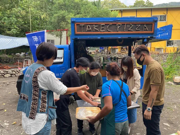 遊客在工作園區戶外學習手作PIZZA，並用餐車窯烤爐或煙燻爐現場燒烤。捌個零社會企業提供