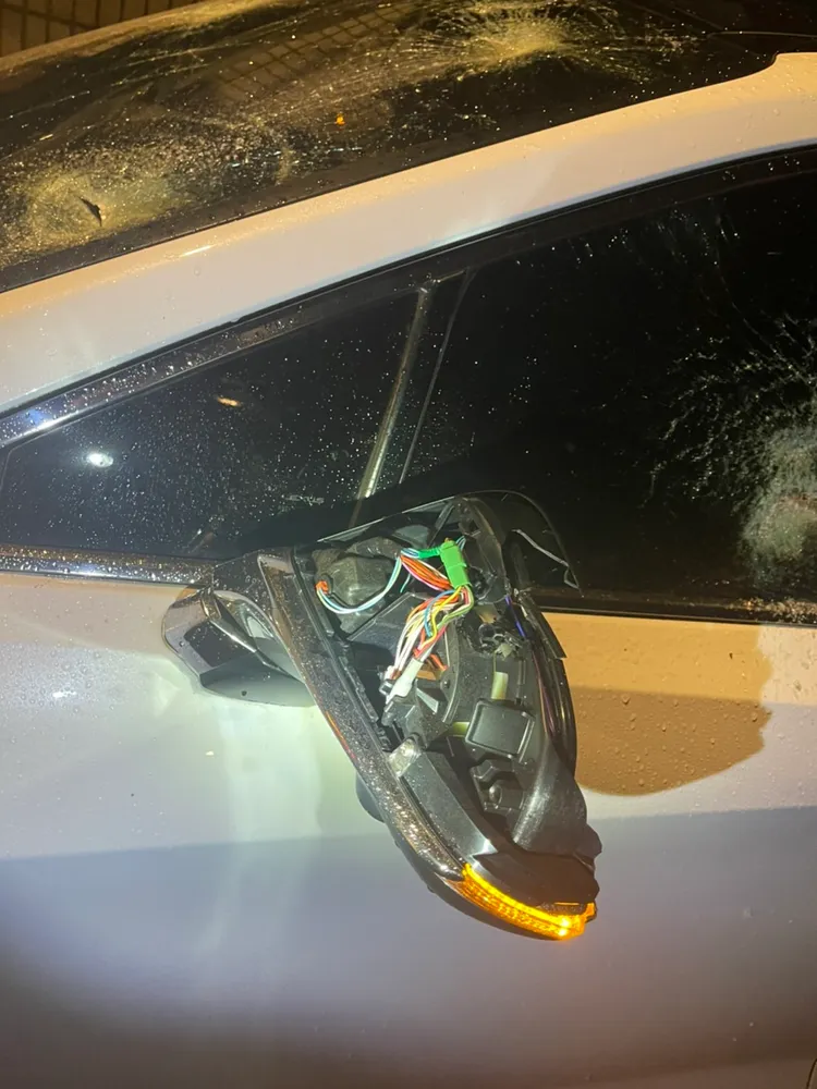 呂男的轎車左後照鏡及擋風玻璃被砸。警方提供