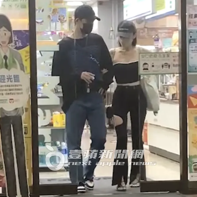 前棒棒堂男孩敖犬（左）拿著咖啡，空姐女友發發則勾著他手步出便利商店。特勤中心攝