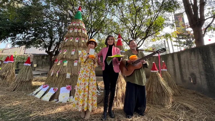 小乖鄭宜雰(左)張鈺萱(中)與陳明章歡樂聖誕樹前合影，為楊桃歌搏版面拚宣傳。魏嘉良攝