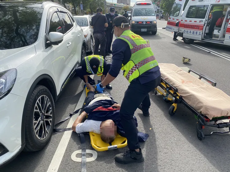 黃男遭闖紅燈休旅車輛撞上後滑向路邊10公尺遠，意識不清仍有氣息。張喆喜攝