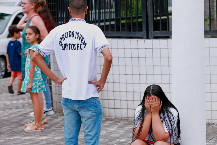 在巴西桑托斯的維拉貝爾米羅體育場外，球迷得知比利死訊後，掩面哭泣。美聯社