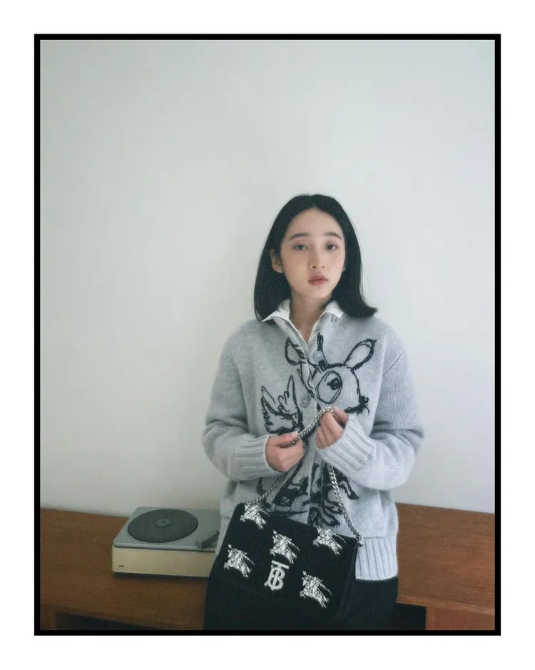 李沐所穿的小鹿圖案開襟針織衫是BURBERRY最新推出的秋冬款，圖案可愛、質材溫暖，她另搭配BURBERRY新款Lola人造水晶馬術騎士裝飾絲絨小型肩背包。翻攝mumoonlee IG