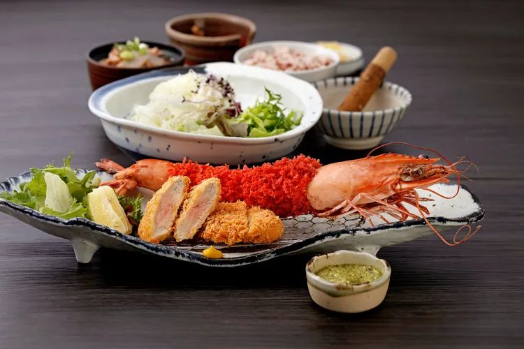 勝勢日式豬排即日起~2023/1/2，推出超霸氣的老虎蝦腰內豬排套餐，其中的巨無霸老虎蝦外層特地以紅麴為之添色。業者提供