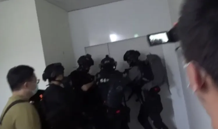 警方荷槍實彈攻堅，破門瓦解博弈詐欺集團。讀者提供