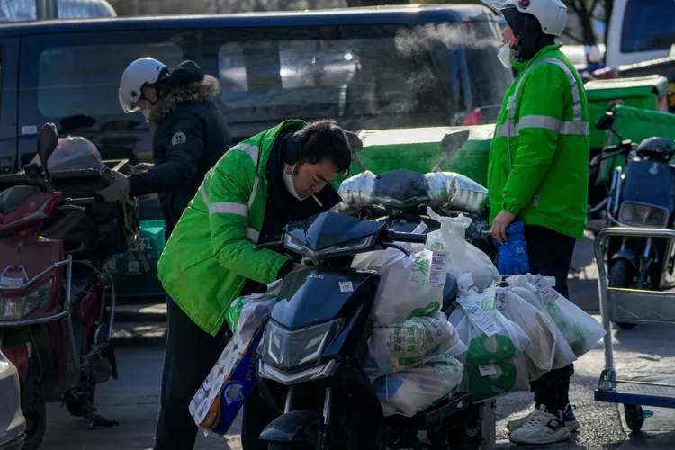 北京外遞員在寒冬中遞送大量包裹、物品。美聯社