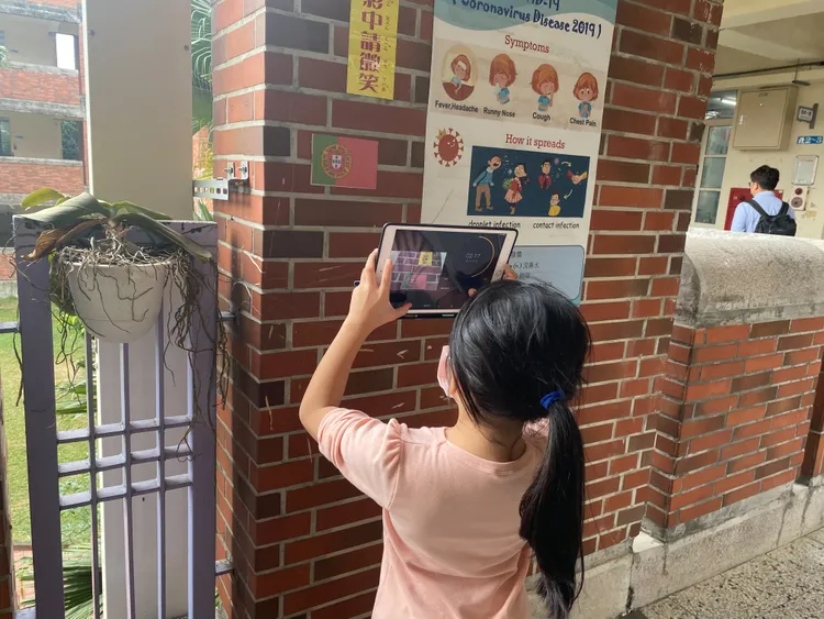 學生在教室附近找足球八強國家的國旗再拍照，讓英文課學習更有互動與樂趣。王雪玲攝