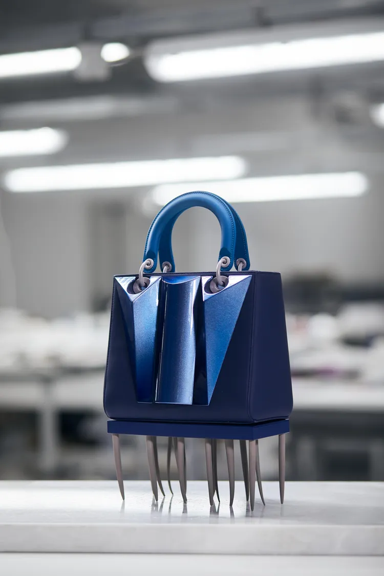 俄羅斯藝術家Zhenya Machneva著眼於女性堅毅及社會對女性施加的壓力等面向，1只包底裝飾可拆卸樹脂針狀物底座的手袋，亦進一步烘托出當今女星於社會中的處境。品牌提供