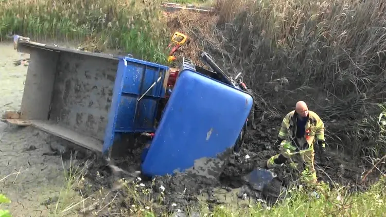 小貨車衝進池塘側翻，司機重傷送醫。讀者提供