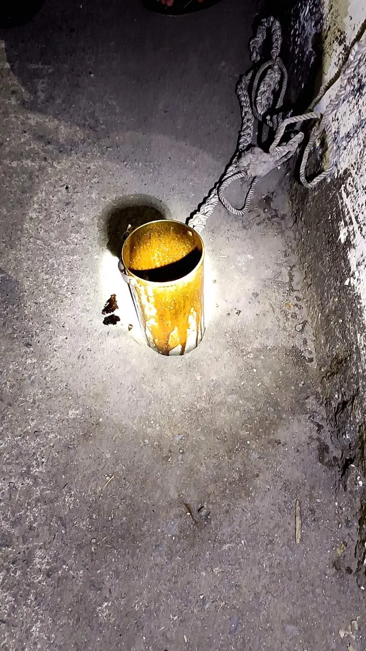 大排水溝旁有一個白色塑膠桶沾滿重油痕跡。讀者提供