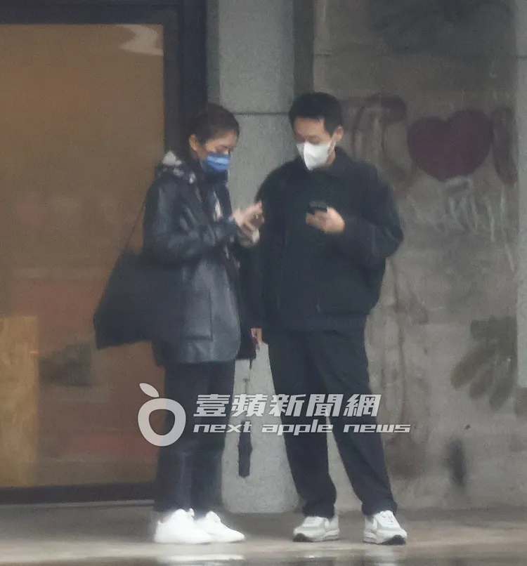 等了一短時間，宋芸樺（左）把握時間划手機。特勤中心攝