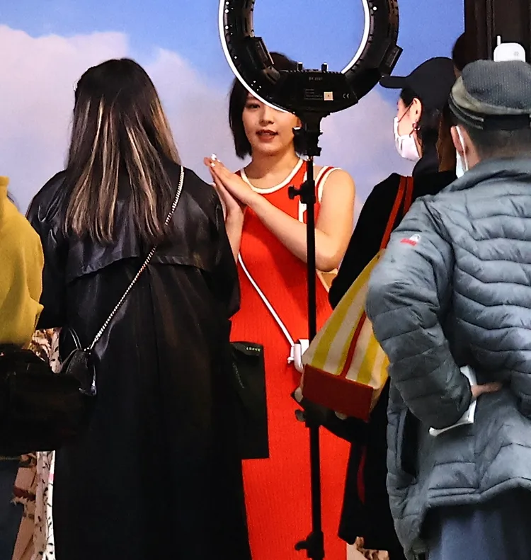 當天品牌活動的劉品言一身亮橘洋裝，比出俏皮姿勢供品牌方拍照。特勤中心攝