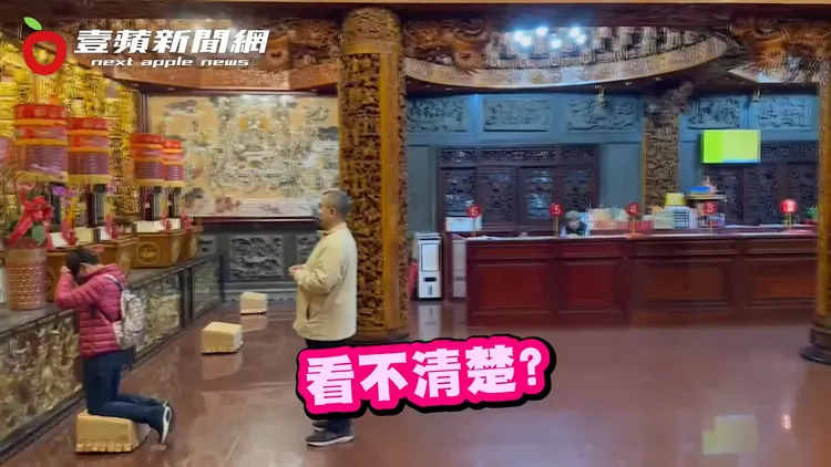 彭愛佳非常虔誠，跪地拜神。林益世則只是拿香站在後方。讀者提供