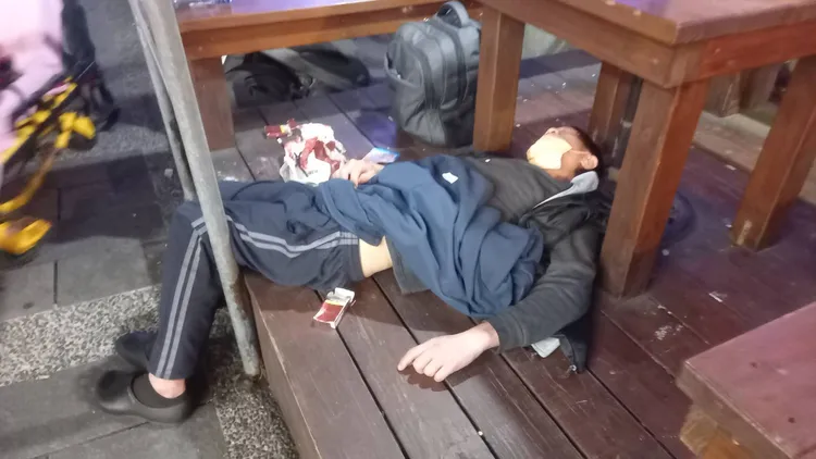 吳姓男子不勝酒力倒在便利店前桌下。李陳信得攝