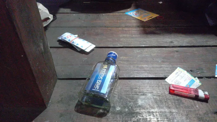 男子身旁有一空酒瓶及安眠藥。李陳信得攝