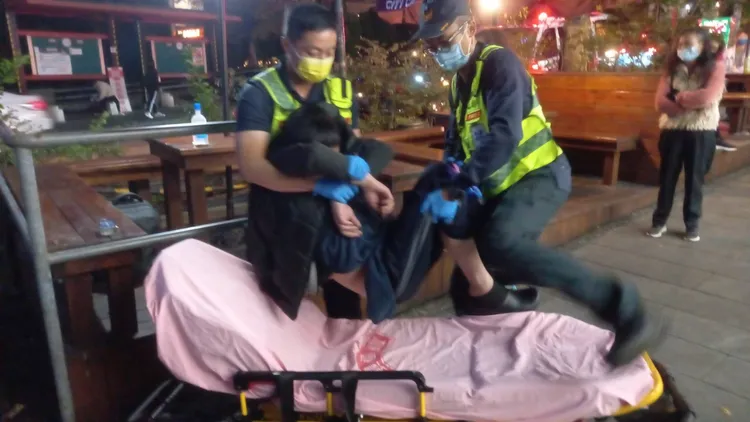 救護人員江男子抬上擔架送醫。李陳信得攝