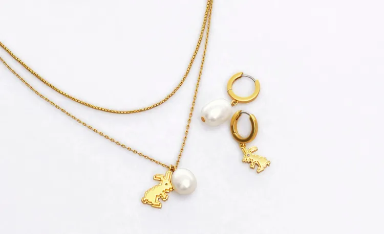 兔年限定福兔迎春富滿堂飾品，雙圈鍊金色像素圖騰兔和橢圓珍珠雙吊飾項鍊（左起） 8690元、不對稱吊墜耳環6490元。品牌提供