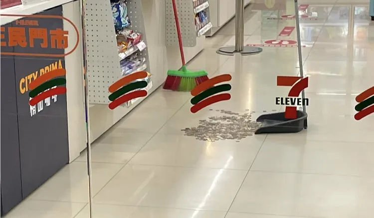 呂男搶奪櫃檯旁的愛心零錢箱時，與超商店員發生扭打，零錢散落一地。翻攝「我們是新店人!! 好山好水，就是愛新店」