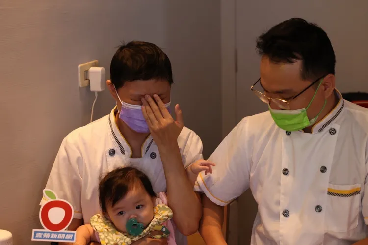 顏伶安（右）挺過懷孕罹癌、抗癌的艱辛，抱著女兒在新開的吐司店裡工作。侯昌騰攝