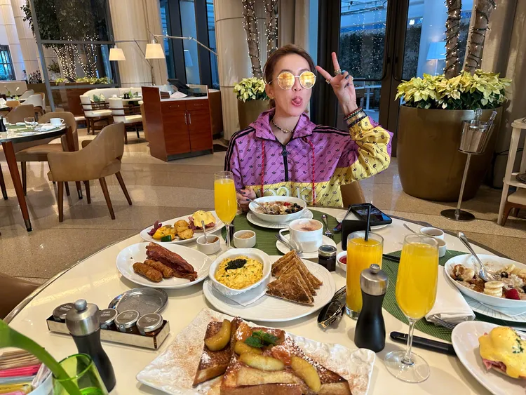 李玟吃著滿桌美食，也亮出身上義大利時裝GUCCI跨界運動品牌adidas的聯名外套。翻攝李玟臉書