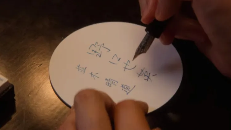 由八木莉可子飾演青春期的女主，在爸爸於杯墊寫下的自己名字旁，用鋼筆寫下初戀男友的名字「並木晴道」。翻攝Netflix畫面