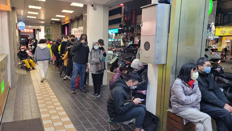 排隊民眾裝備齊全，自備小椅子攤開在騎樓坐著。劉榮輝攝