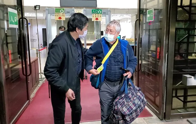 黃良雄拿著大包行李離開北檢，他的律師則在一旁陪著他離開。呂志明攝