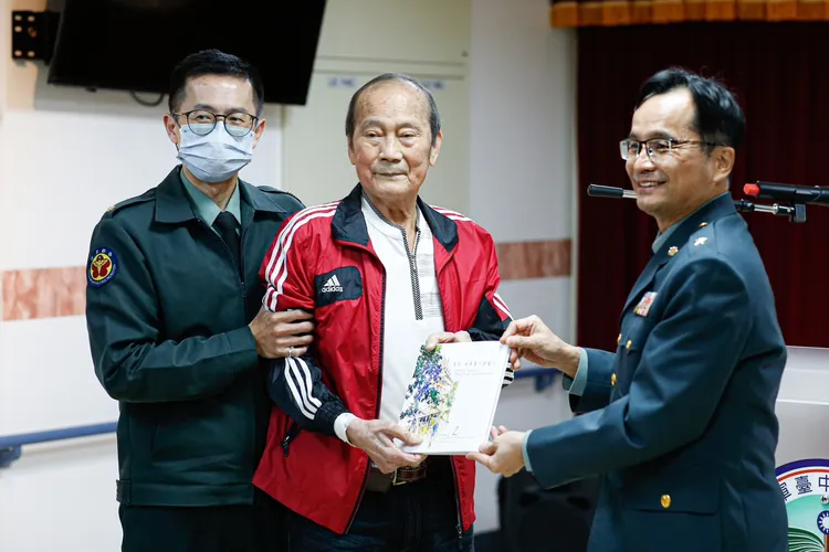 企業家戴正川（中）捐贈畫冊給國軍台中總醫院院長洪恭誠（右）。國軍台中總醫院提供