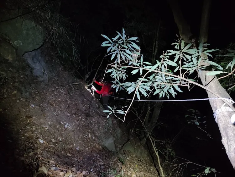 搜救人員先行架設繩索，固定後將受困者帶回步道上。民眾提供