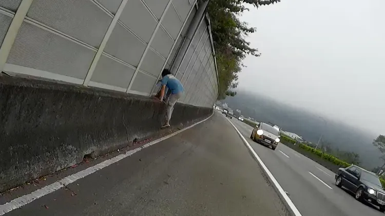 男子跳上路肩護欄。張喆喜攝
