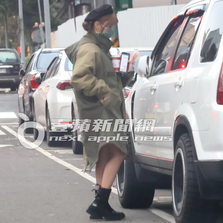 好不容易掏出車鎖匙的巫苡萱，將19公分的熱狗和黑咖啡夾在胸口開車門。特勤中心攝