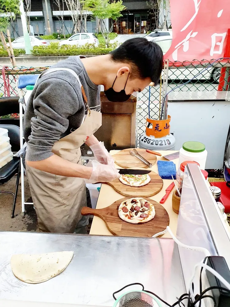 王昱勛選在靠天吃飯的夜市創業，現切剛出爐的披薩。王昱勛提供