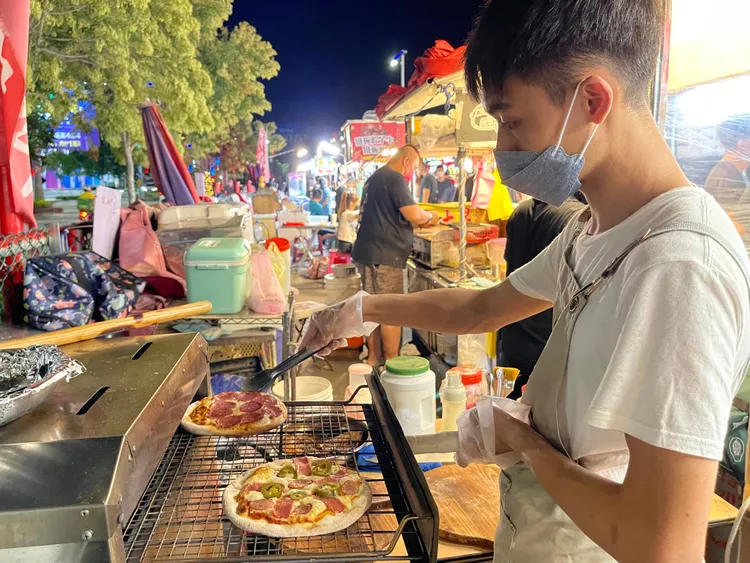 王昱勛將披薩送進烤爐內，隨時掌握烘烤狀況。王煌忠攝