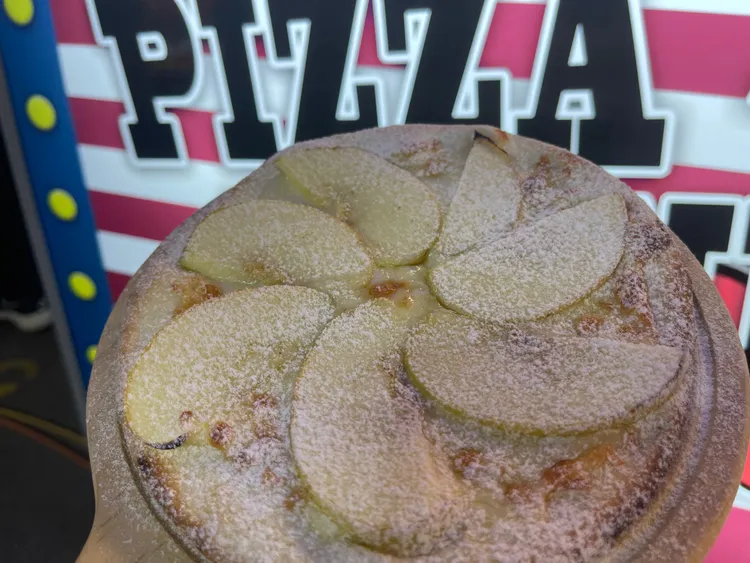 手工披薩餅皮上面鋪滿切片新鮮蘋果，撒上雪白糖粉及少許肉桂粉，也是王昱勛的限量新品之一。王煌忠攝