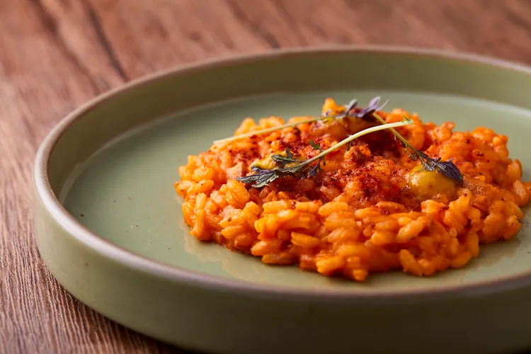 「南瓜燉飯佐牛膝醬和覆盆子」選用ACQUERELLO 義大利頂級陳年米，以火烤三小時的牛骨取其骨髓和花生等一同煨出，並有南瓜、覆盆子等待出酸甜味。業者提供