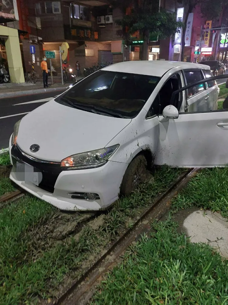 轎車輪胎陷入泥濘中動彈不得。讀者提供