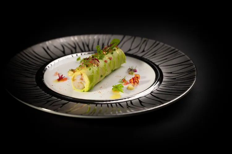 跨年限定套餐開胃前菜「蟹肉 酪梨 金箔 拇指檸檬」做工精美，如花瓣的酪梨切片包裹著雞尾酒調製蟹肉。業者提供